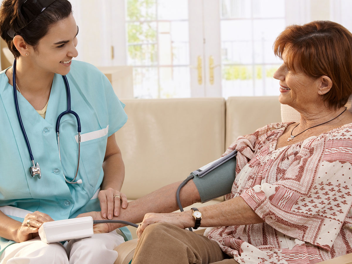 caretaker taking patients blood pressure